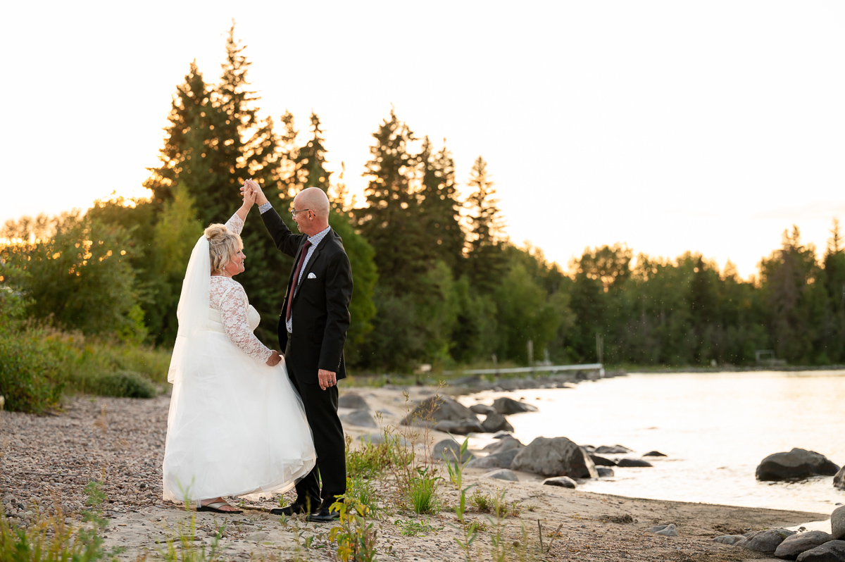 beach elopement dancing photo, sunset session, sunset wedding, bride and groom sunset, bride and groom, wedding photographer, beach session, beach wedding, walking in the sand, sunset elopement, elopement photographer cold lake
