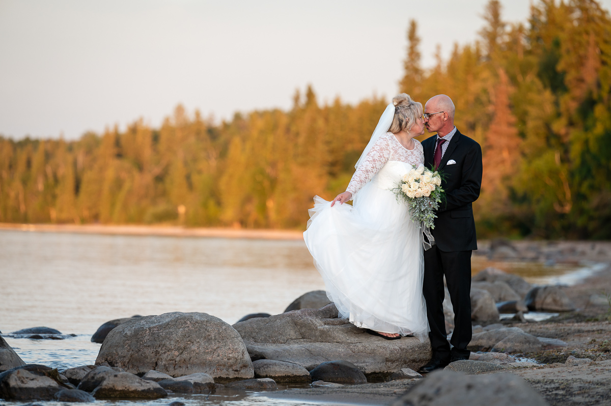 fall beach elopement, sunset session, sunset wedding in cold lake, bride and groom sunset, bride and groom kissing, wedding photographer, beach session, beach wedding, walking in the sand, sunset elopement, elopement photographer cold lake, fall backdrop