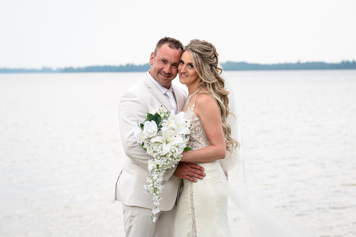 bride and groom posing, wedding kiss, beach wedding, franchere bay campground, storms rolling in, wedding photography, unique wedding photographer, storming wedding, Bonnyville photographer, photographer near me,